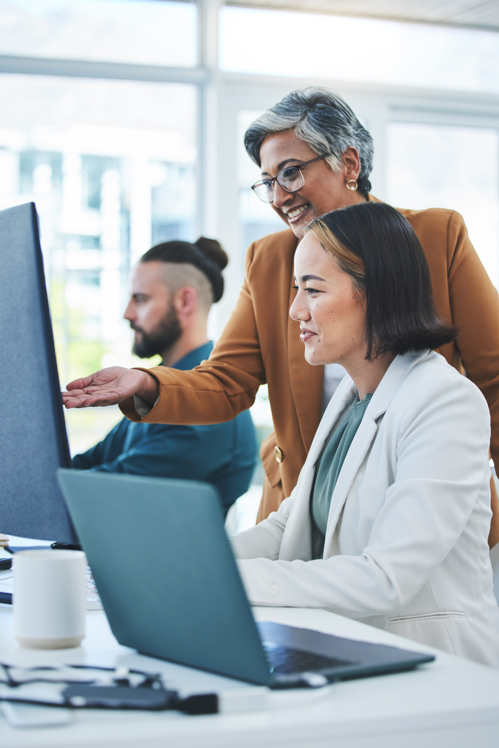 Coaching, mentor and computer with business people in office for planning, solution and teamwork. T.